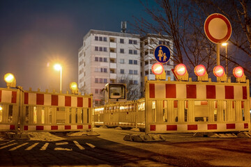 Road barriers with orange and red lamps during road repairs at night in Germany