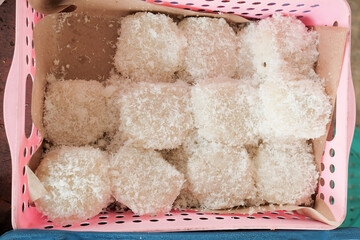 A serving of steamed glutinous rice (ketan) topped with grated coconut, displayed at a traditional...