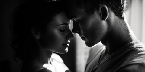 Black and white photograph capturing a romantic moment between two individuals.
