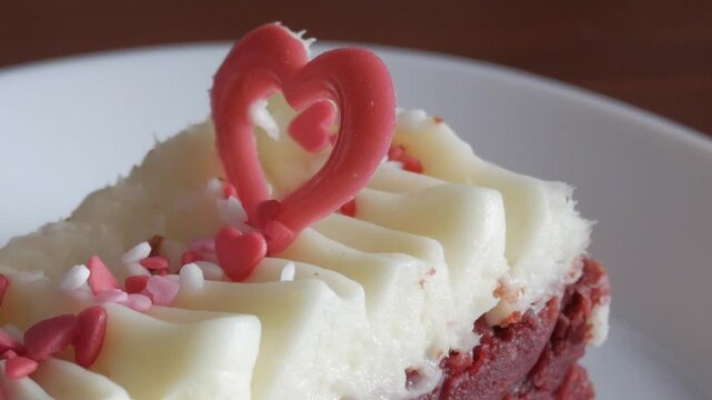 Red velvet brownie with creamy frosting, heart decorations, romantic Valentine's vibe