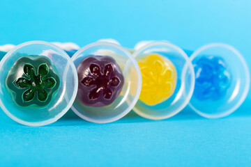 Set of multi-colored gel syringes with disinfectant and toilet cleaner on a blue background, close-up