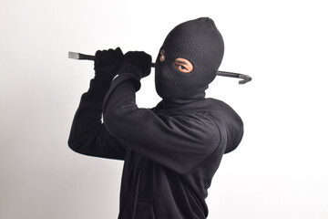 Thief wearing black jacket and mask holding crowbar, isolated on white background.
