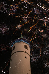 Fireworks bursting over historic tower at night