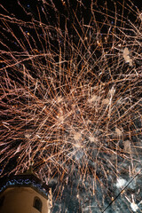 Fireworks bursting over historic tower at night