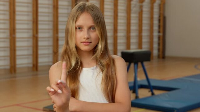 Little Caucasian girl pointing finger no refusal negative gesture arms crossed child schoolgirl kid daughter student pupil school gym sport answer deny rejection forbid learning training sportswoman