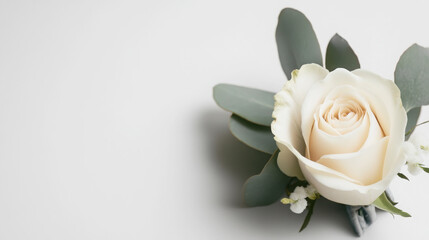 Fototapeta premium Elegant floral boutonniere with delicate white rose and green foliage for wedding decor