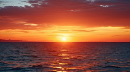 Obraz premium A breathtaking sunset reflects vibrant orange hues across a serene ocean, creating a peaceful atmosphere.