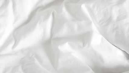 Obraz premium White clean hotel bedsheet with soft texture and smooth fabric folds.