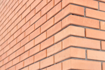 Brick wall side view background. Orange brick wall background for exterior design. Construction concept, outdoor buildings, garage or house. Wall with classic checkerboard pattern and visible joints