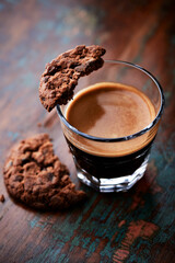 Chocolate cookie and Coffee in glass cup on rustic wooden background. Close up.	