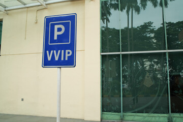 A blue VVIP sign outdoors with a modern building in the background, indicating exclusive or...