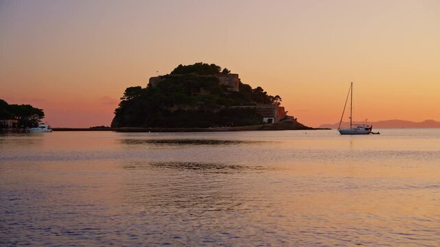 View of Bregancon fort at sunset. A yacht is anchored near the fortress