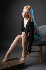 Fototapeta premium Portrait of a blonde woman with freckles in a sexy top and denim shorts in a studio.