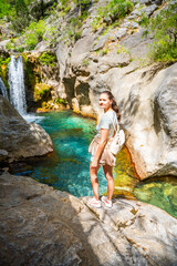 Young woman hiking in Sapadere canyon with wooden paths and cascades of waterfalls in the Taurus mountains, Turkey. Eco tourism concept