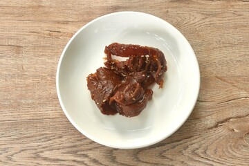 salty and sweet dry fried slice pork meat fermenting in sesame oil on plate
