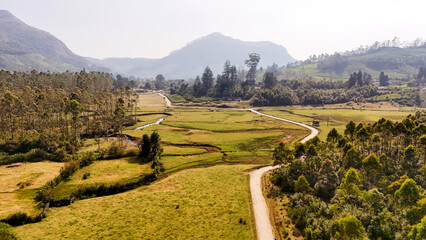 Obraz premium Mesmerizing Drone Shot of Munnar’s Tea Gardens and Picturesque Village, Kerala, and mountains