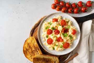 Scrambled eggs with onion and tomatoes on plate
