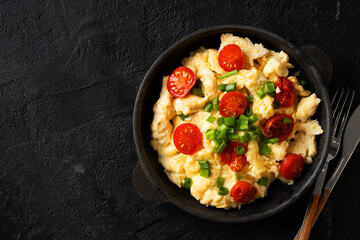 Scrambled eggs with onion and tomatoes on plate
