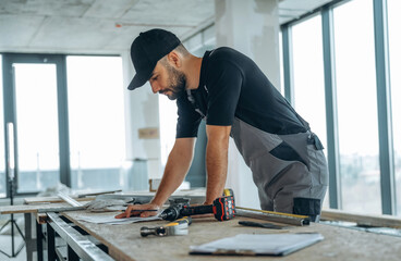 Writing on the paper. A man is renovating an unfinished room