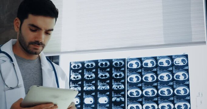 Doctor standing with laptop examine x-ray flim for patient in the hospital.