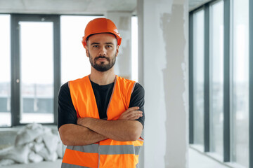 Front view, standing. A man is renovating an unfinished room
