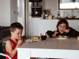 Children enjoying breakfast together in a modern kitchen setting during the morning hours