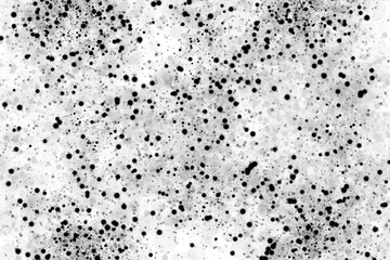 A textured white surface filled with numerous black dots creates a dynamic abstract background perfect for adding depth and visual interest to designs.