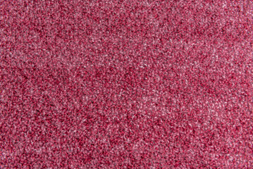Fototapeta premium Close up of pink homemade knitted fabric with large stitches. Textured background