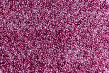 Close up of pink homemade knitted fabric with large stitches. Textured background