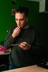 Technician with focused expression on face holding laptop motherboard, examining closely. Concept of meticulous electronics repair, computer hardware, upgrade and technology.