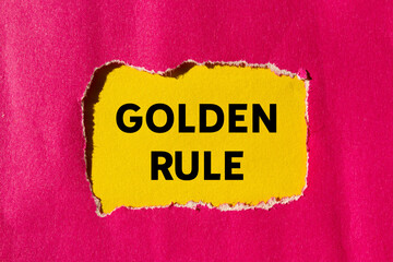 Golden rule message written on ripped torn pink paper on yellow background. Conceptual golden rule symbol. Copy space.