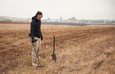 Archeology conception. Man is with metal detector in the field