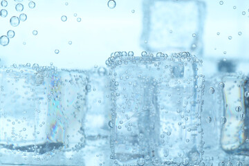 Refreshing soda water with ice cubes in glass, closeup