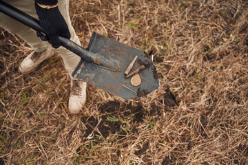 Man found old bullets and coin, sapper, close up view, with shovel