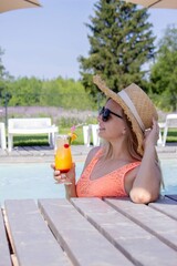 Woman with cocktail near the pool.