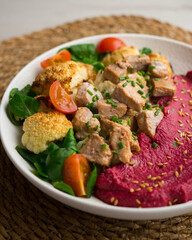 Complete dish with pork, beetroot cream and roasted cauliflower.