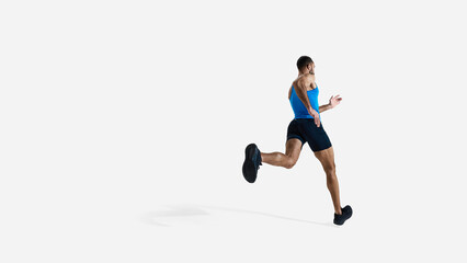 Back view image of muscular athlete, male runner in motion, training isolated on white studio...