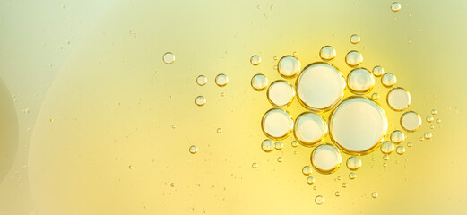 Golden yellow abstract oil bubbles or face serum background. abstract macro cool cosmetics product backdrop. cosmetics product backdrop. Banner 