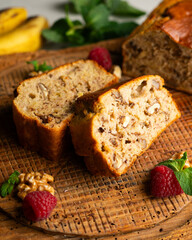Delicious piece of banana and walnut cake on a rustic wooden base.