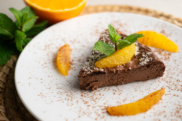 Delicious piece of chocolate cake with fresh orange pieces.