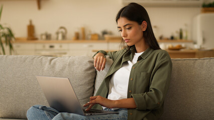 Serious concentrated Indian woman Arabian girl female working studying online at home typing laptop computer pensive looking away thinking ponder author write with pc think idea inspiration solution