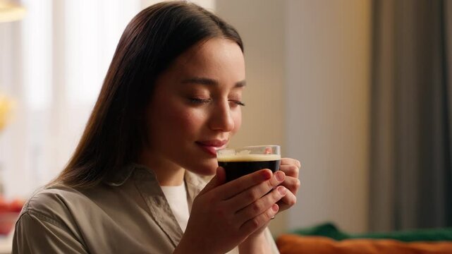 Camp peaceful cozy relaxed Caucasian woman female girl lady homeowner at own apartment indoors relaxing in living room home holding cup of tea sniffing aromatic coffee drinking aroma drink atmosphere