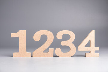 1,2.3,4 wooden numbers set on gray background, step-by-step process