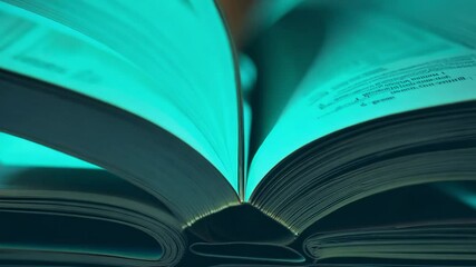 Gentle breeze fans pages of an open book, pan up video, soft teal ambient lighting, creates a calming and ethereal mood, emphasizing vertical - Powered by Adobe