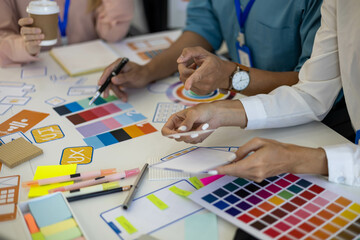 Two people are working on a project together, with one person pointing at a card. The project seems...