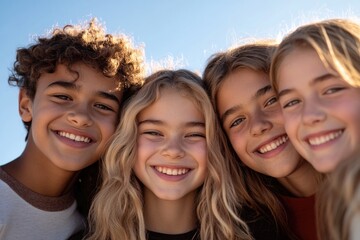 Obraz premium close-up portrait of diverse group of children and teenagers smiling together outdoors during daytime emphasizing friendship