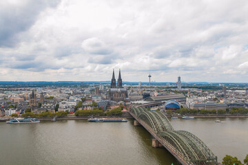 Fototapeta premium view of Cologne Cathedral and the Hohenzollern Bridge. The Gothic architecture of the cathedral contrasts beautifully with the iconic steel structure of the bridge.