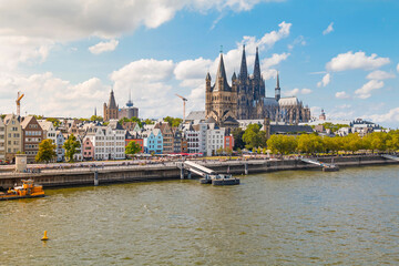 Fototapeta premium view of Cologne Cathedral and the Hohenzollern Bridge. The Gothic architecture of the cathedral contrasts beautifully with the iconic steel structure of the bridge.