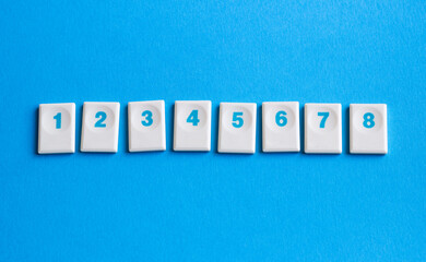 white chips with numbers in ascending order 1 2 3 4 5 6 7 isolated on blue