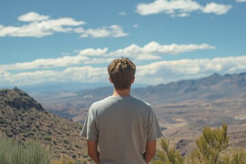 Naklejka premium Joyful Young Man Standing Against Majestic Mountain Views in Gran Canaria - Embracing Nature and Adventure